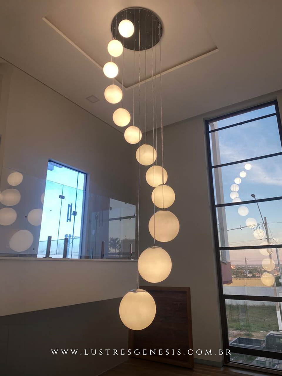 Lustre pendente com 12 globos leitosos foscos, ideal para escadas ou casas com pé direito duplo, da linha Jabuticaba da Loja Gênesis.